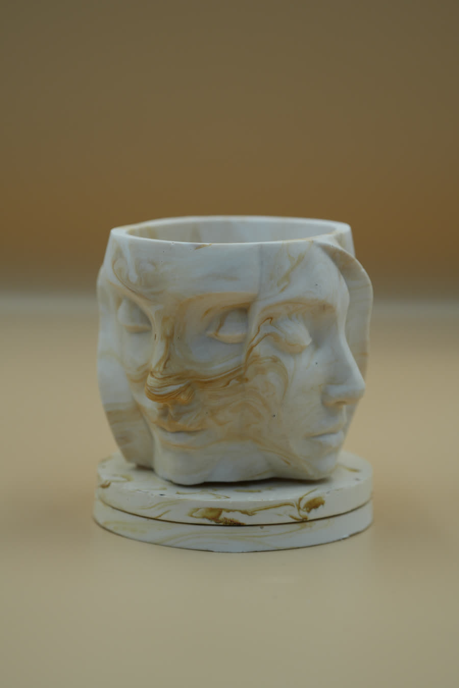 Vessel cast with overlapping sculpted faces